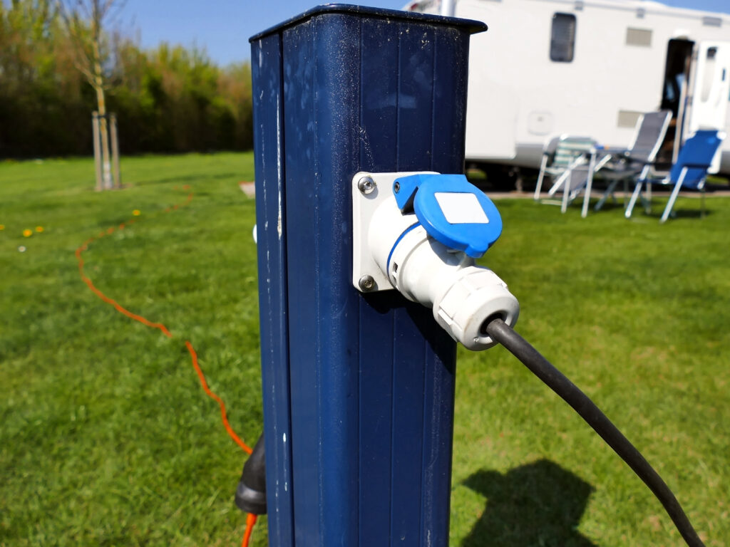 RV electrical hookup at an RV park. Power source stand with electrical cord connected